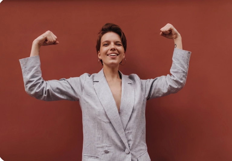 Mujer empoderada y sonriente mostrando fortaleza tras un proceso de crecimiento personal con su psicóloga.