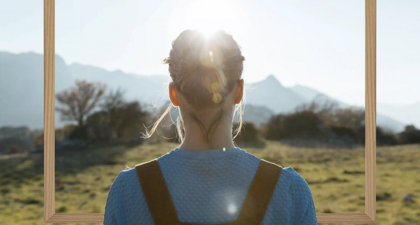 Mujer mirando fijamente a través de una apertura, una metáfora visual sobre mirar más allá de la superficie en terapia.