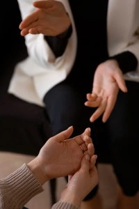 Manos de una psicóloga y su paciente en una sesión de terapia cercana y humana.