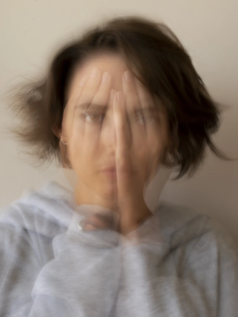 Retrato artístico con efecto de movimiento que representa la confusión y la ansiedad por el síndrome del impostor.